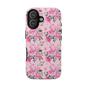 Pu&ograve; includere: Una custodia per telefono con un motivo ripetuto ad acquerello di rose rosa e foglie verdi su sfondo rosa chiaro. La custodia presenta un'area nera ritagliata per la fotocamera in alto a sinistra, adatta a un sistema a doppia lente.
