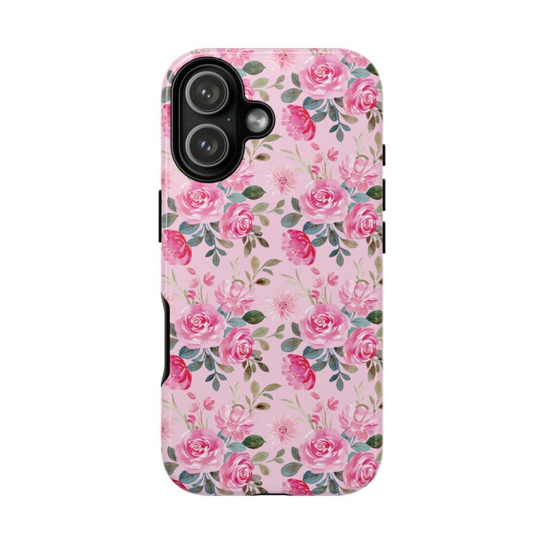 Pu&ograve; includere: Una custodia per telefono con un motivo ripetuto ad acquerello di rose rosa e foglie verdi su sfondo rosa chiaro. La custodia presenta un'area nera ritagliata per la fotocamera in alto a sinistra, adatta a un sistema a doppia lente.