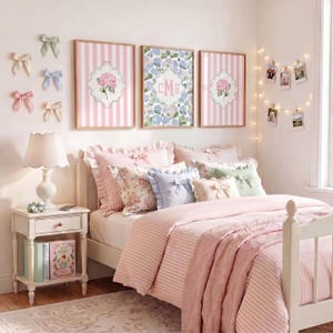 Personalized 3 letter monogram hydrangea wall art above a pink teen girl bed with preppy coquette bedroom decor, pastel bows and striped bedding