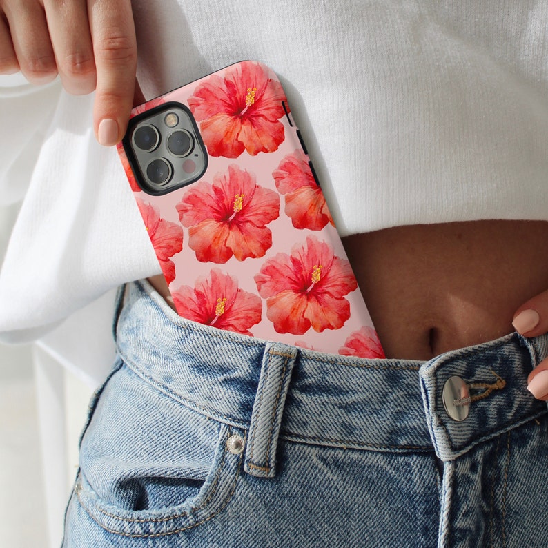 This phone case features a tropical collage pattern of red watercolour hibiscus flowers on a soft pink background. Perfect for coconut girls and beach lovers. Available for iPhone, Samsung and Pixel Phones.