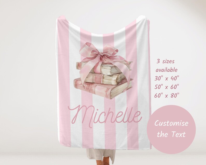 My Custom Name Book Lover Coquette Blanket. Featuring a pink and white striped background with a watercolor book stack wrapped in a bow, this plush blanket is as cozy as it is cute. Add your custom name underneath for a personalized, preppy, coquette touch. Perfect for book lovers, girls bedrooms, baby showers, newborns, or a stylish preppy touch to dorm