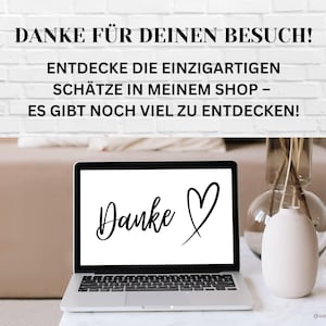 May include: A laptop computer with a white background and the text "Danke" with a heart drawn next to it. The laptop is on a white table with a vase of dried flowers and a glass of water.