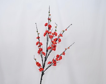 Peut inclure: Branche artificielle de fleurs de prunier avec des fleurs rouges vives et des bourgeons verts. Les branches sombres contrastent avec les fleurs éclatantes. Idéal pour les compositions florales et la décoration intérieure.