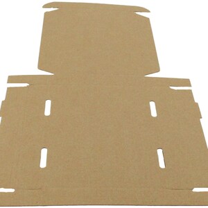 May include: A flat, unfolded cardboard box in a natural brown color. The box has multiple cut-out tabs and slots for assembly. The design suggests it is intended for packaging and shipping of goods. The cardboard is thick and sturdy.