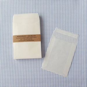 May include: A stack of white, eco-friendly glassine bags made from 100% pine cellulose. The bags are compostable and biodegradable. The text on the label reads: "CICIA IN THE SKY * ciclo.etsy.com Eco-friendly glassine bags made in the UK from 100% pine cellulose. Compostable & biodegradable."