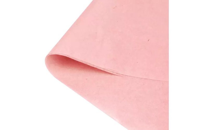 May include: A sheet of light pink tissue paper. The paper has a slightly textured surface.