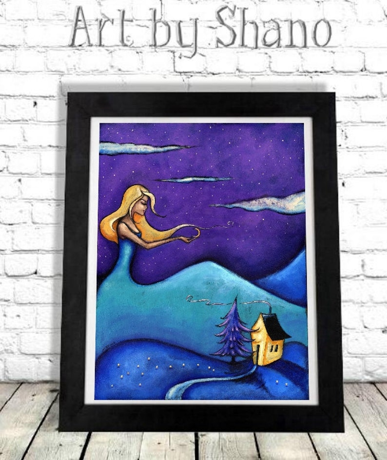 May include: A framed art print with a whimsical illustration. A woman with flowing blonde hair and a blue dress is depicted against a purple starry sky. A small yellow house and a blue tree are in the foreground. The text "Art by Shano" is at the top.