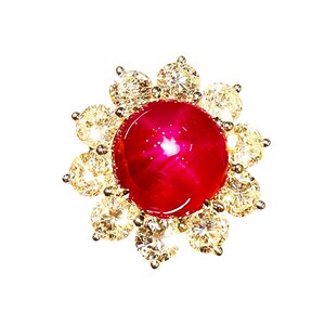 Può includere: Un anello dorato con una grande gemma rotonda di colore rosso scuro al centro, circondata da un alone di gemme rotonde e chiare più piccole. Il design dell'anello ricorda un fiore.