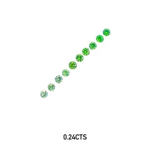 Puede incluir: Una fila diagonal de once gemas redondas y facetadas en tonos verdes variables, de pálido a vibrante. El texto "0.24CTS" está debajo. Las gemas están sobre un fondo blanco.