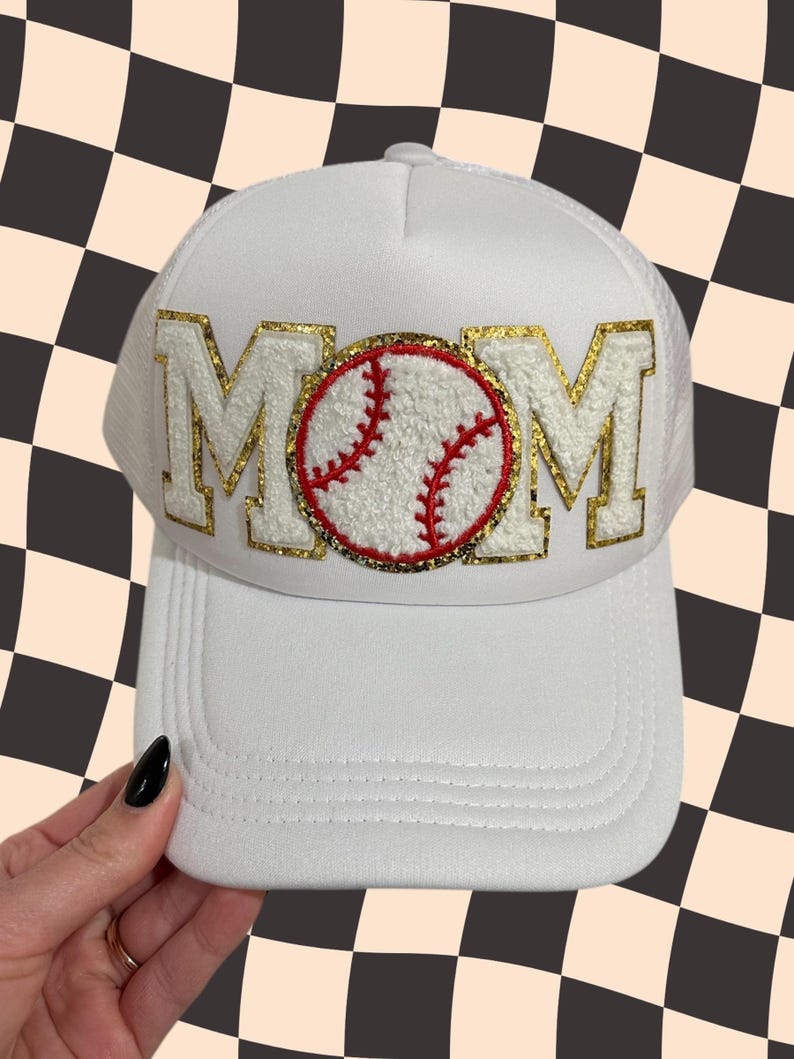 May include: White baseball cap with a gold glitter MOM patch and a red and white baseball graphic.