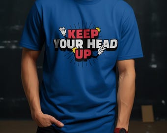 May include: A royal blue t-shirt with a white graphic that says "Keep Your Head Up" in a comic book style font. The graphic features red and yellow accents.
