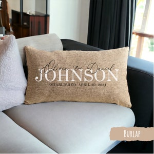 May include: A burlap pillow with the text "Olivia & Daniel JOHNSON ESTABLISHED APRIL 20, 2024" in black and white lettering.