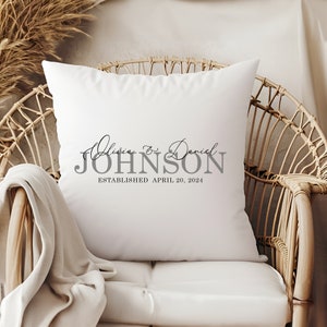 May include: White pillow with the text "Olivia & Daniel JOHNSON ESTABLISHED APRIL 20, 2024" in gray lettering.