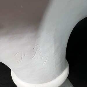 May include: A white plaster bust with the signature "J. Levy" inscribed on the side.