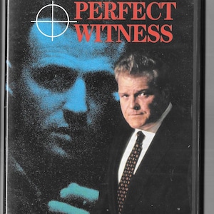 May include: A VHS video cassette cover with a blue and black image of a man's face. The title "PERFECT WITNESS" is in red and white text. The tagline is "It took a mob to run the city- and one man to put them away."
