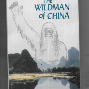 May include: A VHS tape cover for a documentary titled "Adventure: The Wildman of China". The cover features a drawing of a large, hairy creature standing in front of a lake and mountains. The text "mystic fire video" is printed at the bottom of the cover.