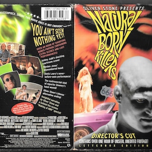 May include: VHS tape for the movie "Natural Born Killers" with a Director's Cut. The cover features a bald man, a woman, and a pink car. Text includes "You Ain't Seen Nothing Yet!" and "Director's Cut".