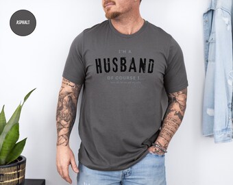 May include: A gray t-shirt with the text "I'm a Husband Of Course I..." printed on the front. The text is in a distressed font.