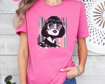 May include: A pink t-shirt with a graphic of a woman wearing sunglasses and a black turtleneck. The graphic is set against a background of colorful abstract lines and dots.