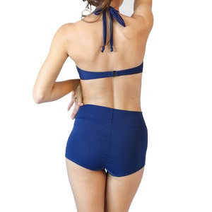 Classic navy blue high waisted retro bikini bathing suit with metal star buttons Navy boy shorts paired with a vintage look halter top. image 3