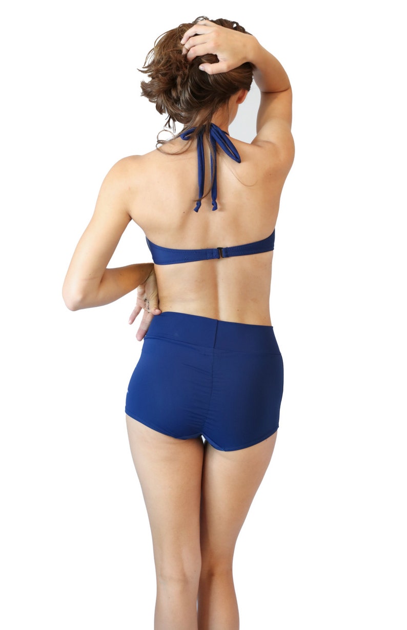 Classic navy blue high waisted retro bikini bathing suit with metal star buttons Navy boy shorts paired with a vintage look halter top. image 3