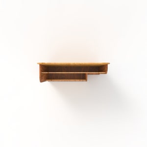 Peut inclure: Une &eacute;tag&egrave;re murale en bois avec deux &eacute;tag&egrave;res. L'&eacute;tag&egrave;re est en bois brun clair avec une teinte brun fonc&eacute;. L'&eacute;tag&egrave;re est fix&eacute;e &agrave; un mur blanc.