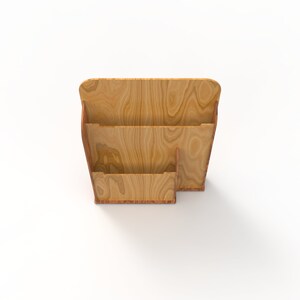 Peut inclure: Un porte-revues en bois avec trois compartiments. Le porte-revues est en bois brun clair avec un grain de bois naturel.