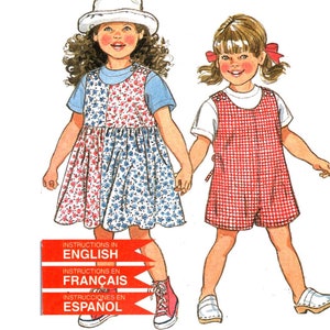 May include: A sewing pattern for children's clothing. The image features illustrations of two young girls wearing dresses and overalls. The pattern includes instructions in English, French, and Spanish. The words "NEW LOOK" and "...for Kids" are also visible.