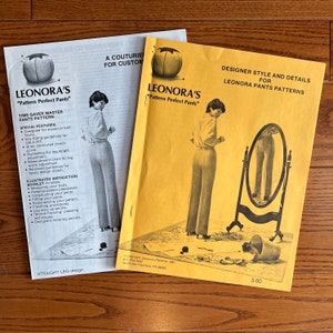 May include: Two sewing pattern instruction booklets for Leonora's "Pattern Perfect Pants". The front cover of the booklet on the left shows a woman wearing pants and the front cover of the booklet on the right shows a woman standing in front of a mirror.