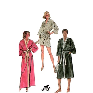 Könnte beinhalten: Illustration von drei Bademänteln in verschiedenen Stilen. Der Bademantel links ist lang und rosa mit cremefarbenem Besatz und Gürtel. Der mittlere Bademantel ist kurz, mit einem floralen Muster. Der Bademantel rechts ist dunkelgrün mit weißem Besatz und Gürtel. Das Jiffy-Logo befindet sich unten in der Mitte.