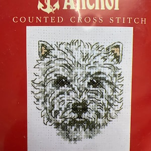 May include: A counted cross stitch kit by Anchor featuring a Westie dog design. The kit includes 14bpi White Aida and Anchor Stranded Cotton. The finished design measures 4 1/4" x 3 1/4". The packaging is red with the Anchor logo and the words "COUNTED CROSS STITCH".