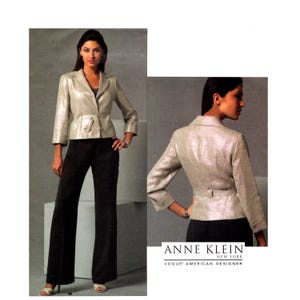 Puede incluir: Un blazer plateado metalizado con mangas tres cuartos, cuello con solapas y cinturón en la cintura, combinado con pantalones negros. El texto dice ANNE KLEIN NEW YORK VOGUE AMERICAN DESIGNER. El blazer se muestra desde la parte frontal y trasera.