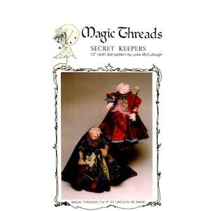 May include: A Magic Threads Secret Keepers 12-inch cloth doll pattern by Julie McCullough. The cover features two dolls in elaborate, layered fabric outfits, one in deep red and one in black, with detailed lace and patterned textile accents.