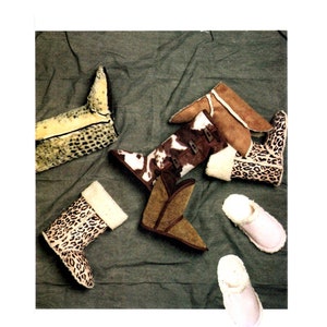 May include: A collection of footwear including several boots and slippers. Features include a leopard print boot with white lining, a brown and white cow print boot with toggle closures, a tan suede boot, a brown suede boot, and two light pink slippers.