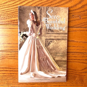 Puede incluir: Portada del libro "Sew a Beautiful Wedding" con una novia vestida de novia marfil con lazos. La portada también incluye los nombres de Gail Brown y Karen Dillon, y la editorial, A Palmer/Pletsch Publication.