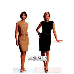 May include: Two sleeveless sheath dresses, one in tan and one in black, each featuring a round neckline and a matching belt at the waist. The text ANNE KLEIN VOGUE AMERICAN DESIGNER is printed in black at the bottom center of the image.