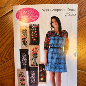 Pode incluir: Um padrão de costura intitulado "Well Composed Dress & Blouse" com uma mulher vestindo um vestido azul estampado com cinto preto e mangas florais. O padrão inclui imagens de bordados florais.