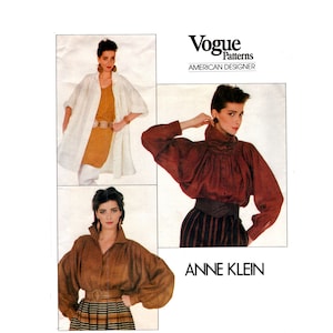 May include: Vogue Patterns American Designer Anne Klein sewing pattern featuring three different views of a blouse with puffed sleeves. The pattern is for a women's blouse with a high neck and a gathered detail at the neckline.