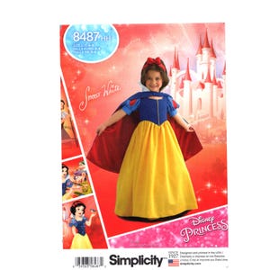 Può includere: Modello di cucito Simplicity per un costume da Biancaneve. Il modello mostra una bambina con un vestito blu e giallo con un mantello rosso. La confezione include il testo "Disney Princess" e il numero "8487HH".