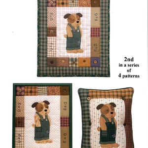 Puede incluir: Un patrón de patchwork con un perro de dibujos animados con overoles, con el texto "Little Dog" en la parte superior. El diseño es parte de la serie "Storybook Animals", con el número 2 mostrado. La imagen incluye un edredón, un cuadro enmarcado y una almohada.