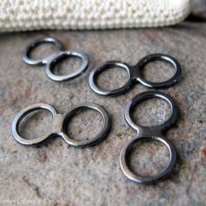 May include: Four silver-toned metal double loop connectors. Each connector has two circles connected by a bar.