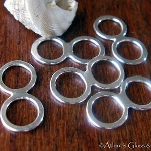 May include: Silver double loop connectors, also known as jump rings, are a popular jewellery making supply. These rings are perfect for connecting chains, cords, and other jewellery components.