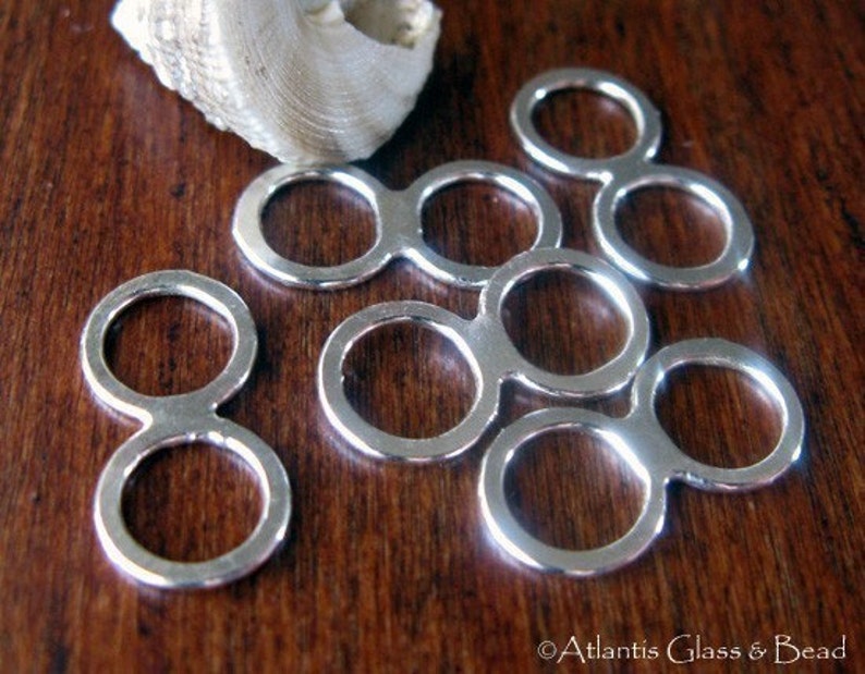 May include: Silver double loop connectors, also known as jump rings, are a popular jewellery making supply. These rings are perfect for connecting chains, cords, and other jewellery components.