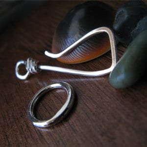 May include: A silver wire ring and a silver wire hook with a twisted wire detail. The hook is bent into a curved shape.