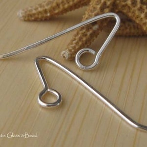 May include: Two silver earring hooks with a loop at the end. The hooks are made of metal and are designed to be used with earrings.