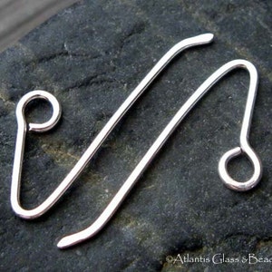 May include: Two silver-toned metal earring hooks with a loop at the end. The hooks are bent into a V-shape.