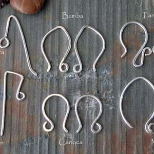 May include: A close-up of ten different styles of silver earring hooks. The hooks are arranged in two rows of five. The hooks are labelled with names such as "Zora", "Bamba", "Tango", "Cajon", "Canocha", and "Mambo".