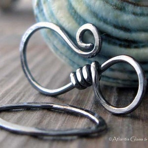 May include: Silver-toned metal clasp with a decorative swirl design. The clasp is open and ready to be attached to a necklace or bracelet.