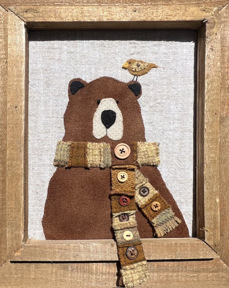 May include: A brown bear wearing a plaid scarf with brown buttons. A small yellow bird sits on top of the bear's head.