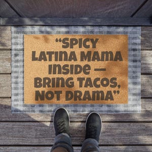 May include: A brown coir doormat with white trim and the text "Spicy Latina Mama inside - Bring Tacos, Not Drama" printed in black.